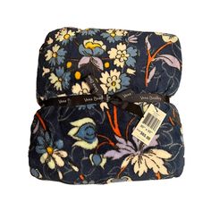 two pieces of blue and yellow floral fabric with black ribbon on each side, one piece has