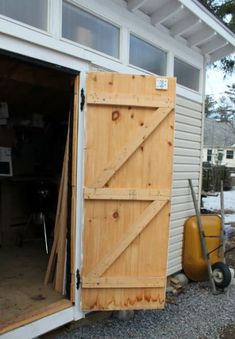 an open garage door on the side of a house next to a wheelbarrow