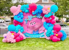 an inflatable photo frame with balloons, flowers and a cartoon character on it