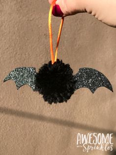 someone is holding up a fake bat ornament