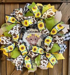 a welcome wreath with sunflowers and a cow is on the front door for someone's house