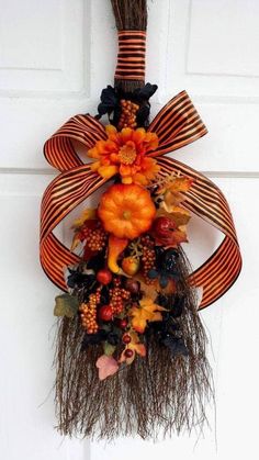 an orange and black wreath hanging on the front door