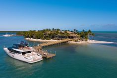 a boat in the water next to a small island with palm trees and houses on it