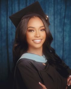 a woman wearing a graduation cap and gown with her arms crossed in front of her chest