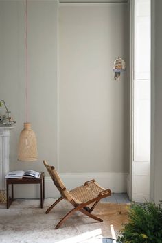 a chair and table in a room with a light fixture on the wall above it