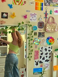 a woman standing in front of a wall full of magnets and pictures on it