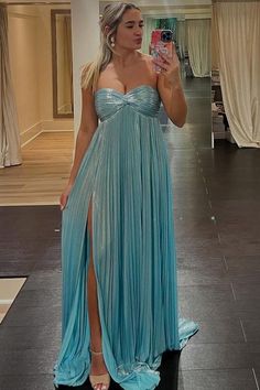 a woman in a blue dress taking a selfie