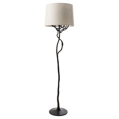 a floor lamp with a white shade on the base and a black metal pole that is holding a light bulb