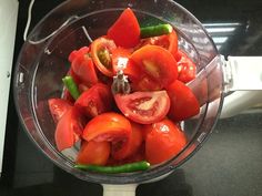 a blender filled with sliced tomatoes and green peppers