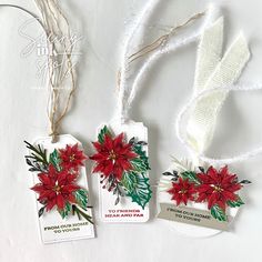 three tags decorated with poinsettis and ribbons