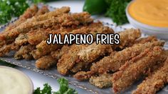 there are several fried food items on the plate with dipping sauces in the background