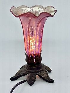 a pink glass lamp sitting on top of a table