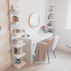 a white desk and chair in a room with shelving on the wall behind it