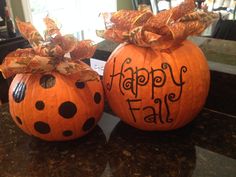 two pumpkins decorated with bows and the words happy fall written in black on them