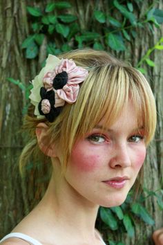 a woman with blonde hair wearing a flower in her hair