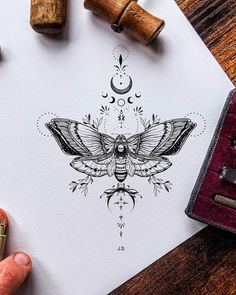 a drawing of a moth on top of a piece of paper next to some stamps