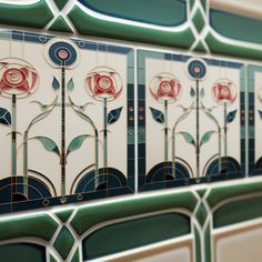 decorative tiles with roses on them are displayed in a wall or window frame, as well as an ornamental design