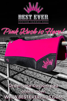 a pink and black purse sitting on top of a fence