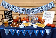 a table topped with food and drinks on top of a blue cloth covered tablecloth