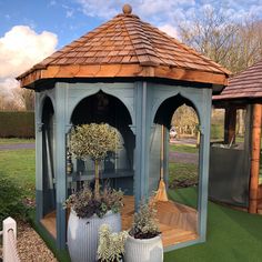 an outdoor gazebo with potted plants in it