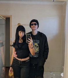 a man and woman taking a selfie in the bathroom