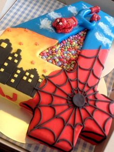 a spiderman themed cake is sitting on a table