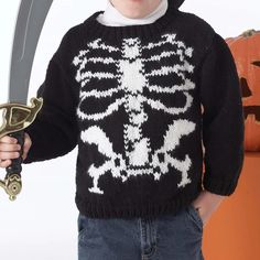 a young boy wearing a skeleton sweater holding a knife