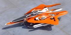 an orange and white skis laying on top of a cement floor next to each other