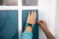 a person is pressing buttons on a glass door with a wristband attached to it