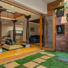 the inside of a house with grass and wooden posts in it's yard area