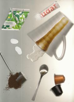 an assortment of items that include coffee, spoons and tea bags on a table