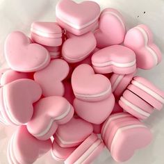 some pink heart shaped cookies on a white surface