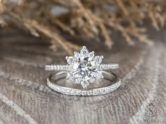 an engagement ring and wedding band are sitting on top of a fur - covered surface