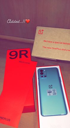 the oneplus phone is in its box next to it's cardboard packaging