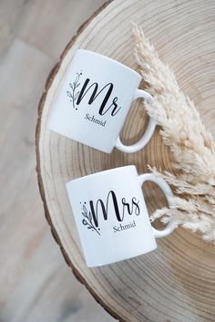 two white coffee mugs with the word mr and mrs on them sitting next to each other