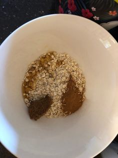 a white bowl filled with oatmeal and peanut butter on top of a table