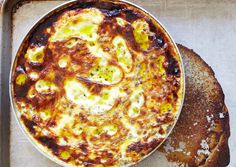 a pizza sitting on top of a metal pan next to a piece of toasted bread