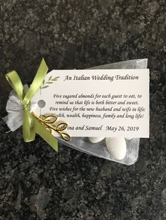 a card with some white balls and a green ribbon on it that says an italian wedding tradition