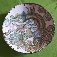 a decorative plate sitting on top of a green tablecloth