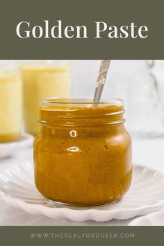 a jar filled with yellow paste sitting on top of a white plate