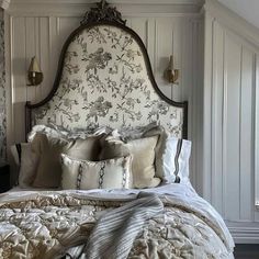 a large bed with pillows and blankets on it's headboard in a bedroom