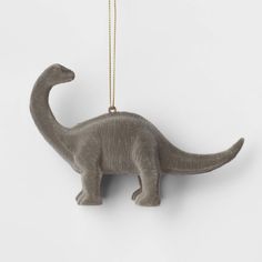 a gray dinosaur ornament hanging from a gold chain