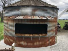 an old round metal structure sitting in the middle of a field