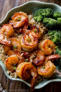 shrimp, broccoli and rice in a bowl on top of a wooden table