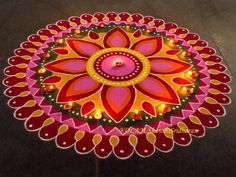 a decorated table with candles on it in the shape of a flower and leaves design