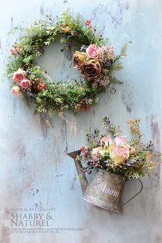 two metal buckets filled with flowers and greenery