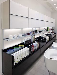 an empty pharmacy room with lots of bottles on the counter and sinks in front of it