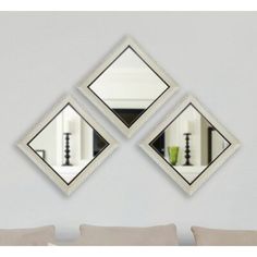 three mirrors mounted to the side of a wall next to a couch and coffee table