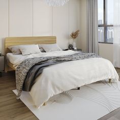 a large white bed sitting in a bedroom under a chandelier next to a window