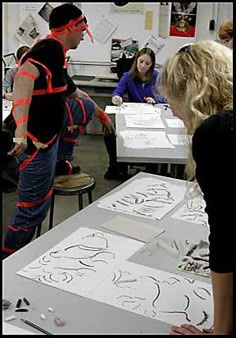 a man and woman standing in front of some drawings